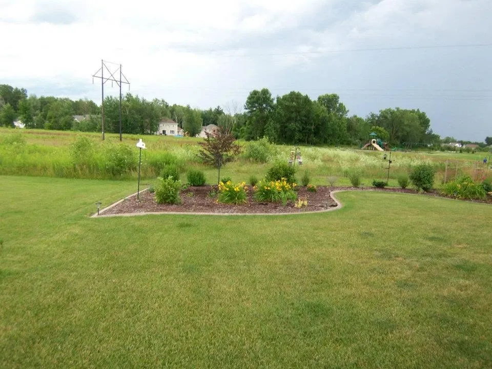 Open green lawn with a landscaped bed on a commercial property
